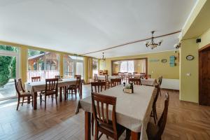 a dining room with tables and chairs and windows at Pensiunea Mirabilandia in Negreni +68 photos