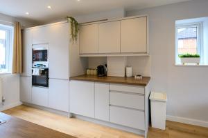 una cucina con armadietti bianchi e una finestra di Dings House With FREE Parking In Super Central South West City Location By StayStaycations a Bristol