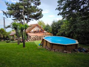 a large swimming pool in a yard with a house at Panoráma Apartman Alsóörs in Alsóörs