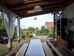 a picnic table on a patio with a view of a yard at Panoráma Apartman Alsóörs in Alsóörs