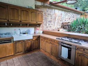 a kitchen with wooden cabinets and a sink at Panoráma Apartman Alsóörs in Alsóörs