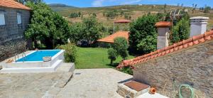 ein Haus mit einem Swimmingpool im Hof in der Unterkunft Casa da Rosa Porreiras in Paredes de Coura