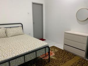 a bedroom with a bed and a dresser and a mirror at Zahra homestay in Seremban