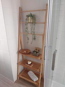 a wooden shelf in a bathroom next to a shower at App Milano Retrò 5 min Humanitas, Forum Assago, Navigli in Rozzano +18 photos