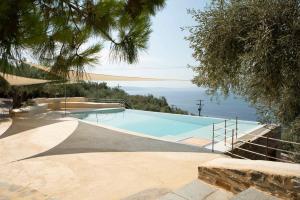 a swimming pool with a view of the ocean at Cypresses Villas in Áno Gatzéa