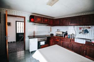 a kitchen with wooden cabinets and a white stove top oven at Peaceful place in São Vicente in São Vicente