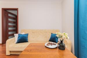 a living room with a couch and a table with a plate of food at Flatbook Apartamenty - Morski Zakątek Stegna in Stegna