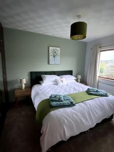 a bedroom with a bed with towels on it at Eileen's Cottage in Castlerock
