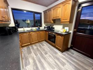 a kitchen with wooden cabinets and a large window at Eileen's Cottage in Castlerock