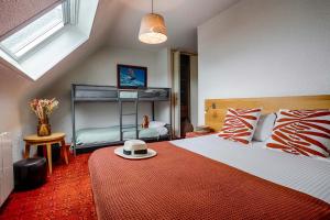 a bedroom with a bed with a hat on a table at Hotel Le Branhoc - Brit Hotel Auray in Auray