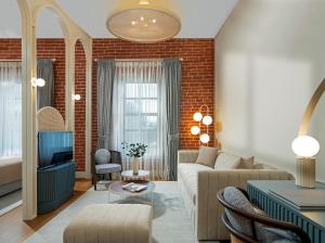 Ecole St. Pierre Hotel في إسطنبول: غرفة معيشة مع أريكة وتلفزيون