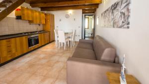 a living room and kitchen with a couch and a table at Sardinianworld - Frontemare Apartment-Funtana Meiga in Funtana Meiga