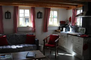 a living room with a couch and a kitchen at B&B Maarle in Poppel