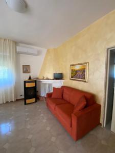 a living room with a red couch and a table at Villa Mima in Santeramo in Colle