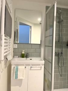 a white bathroom with a sink and a mirror at 731 Joli studio mezzanine proche du métro L9 in Bagnolet