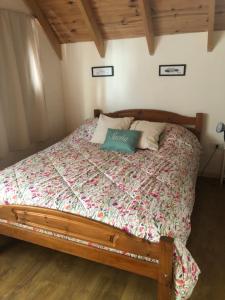 a bedroom with a bed in a room with wooden ceilings at La Joaquina, Casa de montaña. in El Chalten