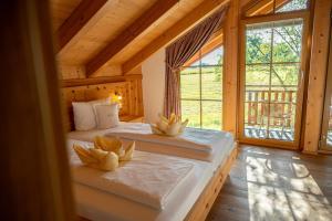 zwei Betten in einem Zimmer mit großem Fenster in der Unterkunft Bayern Chalets bei Salzburg und Berchtesgaden mit Whirlpool und Sauna in Ainring + 198 Fotos