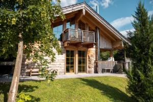 een blokhut met een terras en een balkon bij Bayern Chalets bei Salzburg und Berchtesgaden mit Whirlpool und Sauna in Ainring +186 foto's