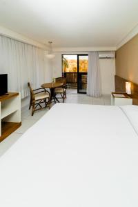 Uma TV ou centro de entretenimento em Porto Suítes Natal Hotel