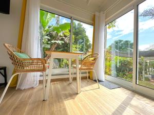 a white table and two chairs in a room with large windows at Studio at FLAMINGA S PLACE in Lajes do Pico