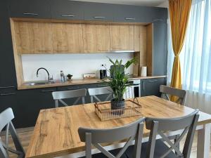 une cuisine avec une table en bois avec une plante dessus dans l'établissement home as home, à Cluj-Napoca
