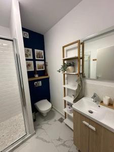 une salle de bain avec toilettes, lavabo et miroir dans l'établissement home as home, à Cluj-Napoca
