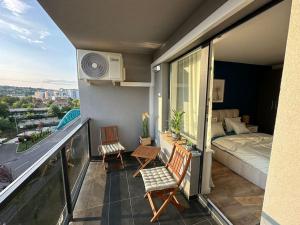 - un balcon avec deux chaises et un lit ainsi qu'une chambre dans l'établissement home as home, à Cluj-Napoca