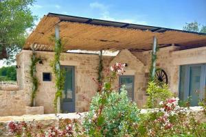 a stone house with a wooden roof at Luxury Suite & Spa Trullo Monte Farella in Putignano