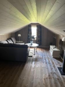 a living room with a couch and a table at Bjørkefinken by Norgesbooking - cabin for hiking and skiing in Tisleidalen