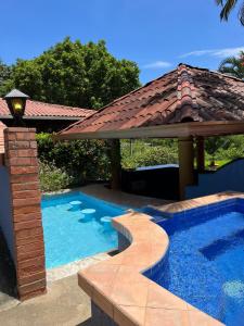 a swimming pool with a gazebo and a house at Siwõ Art Guesthouse in Ocotal +80 photos