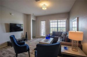 a living room with a couch and a table and chairs at The Epic Boca Penthouse Vista Cay Orlando in Orlando
