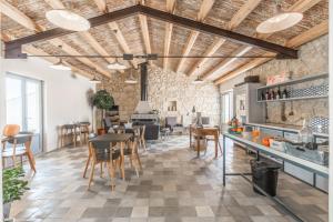 duża kuchnia z drewnianymi sufitami, stołami i krzesłami w obiekcie Mangiabove w mieście Marina di Ragusa