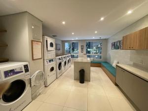 a large laundry room with washing machines and a kitchen at FOR Consolação in Sao Paulo
