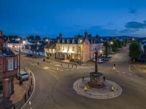 een straat in een stad 's nachts met gebouwen bij Buccleuch and Queensberry Arms Hotel in Thornhill