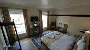 a bedroom with a canopy bed and a television at Bacchus Hotel in Sutton on Sea