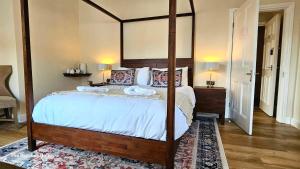a bedroom with a large bed with a wooden frame at Bacchus Hotel in Sutton on Sea