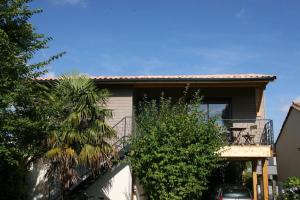 ein Haus mit einem Balkon und einem Auto vor dem Haus in der Unterkunft Maison 2ch, Parking, à 10min de Bx, Calme in Mérignac