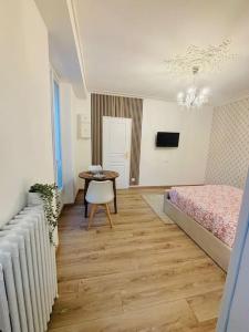a bedroom with a bed and a table with a chair at Le Royal, proche Paris & Disney in Noisy-le-Grand