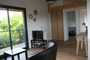 ein Wohnzimmer mit einem schwarzen Stuhl und einem TV in der Unterkunft Maison 2ch, Parking, à 10min de Bx, Calme in Mérignac