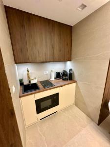 a small kitchen with a sink and a microwave at Masarska 8 VIP Apartamenty JACUZZI in Kraków