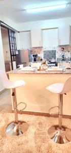 a kitchen with two stools in front of a counter at Golden Touch Luxury Superior in Nairobi