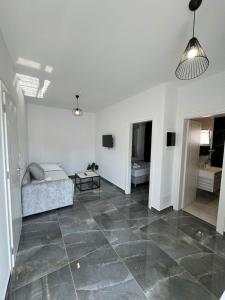 a living room with a bed and a large tile floor at Nōya Suites SR in Sarandë