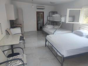 Habitación con 3 literas, mesa y sillas. en AlMa, en Asprovalta
