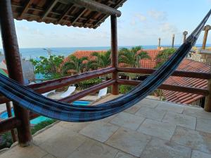 a hammock on a balcony with a view of the ocean at Pousada TERRA NOVA in Aracati