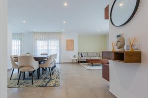 a dining room and living room with a table and chairs at Luxuosa Villa Baía in Alfeizerão