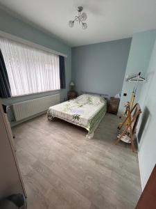 una camera con letto, finestra e ventilatore di Chambre dans habitat partagé chez Séverine a Nivelles