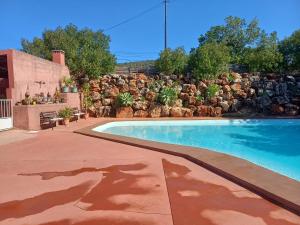 a swimming pool in front of a stone wall at Quinta do Baquenéu- Sitio das Cortes in Cortes
