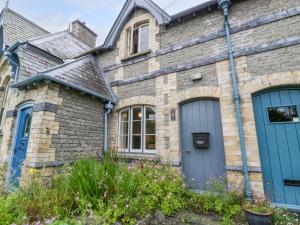 ein Steinhaus mit blauen Türen und Blumen in der Unterkunft Teacher's Cottage in Presteigne
