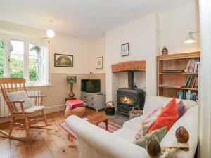 ein Wohnzimmer mit Couch und Kamin in der Unterkunft Teacher's Cottage in Presteigne