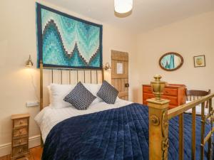 ein Schlafzimmer mit einem Bett und einem Gemälde an der Wand in der Unterkunft Teacher's Cottage in Presteigne